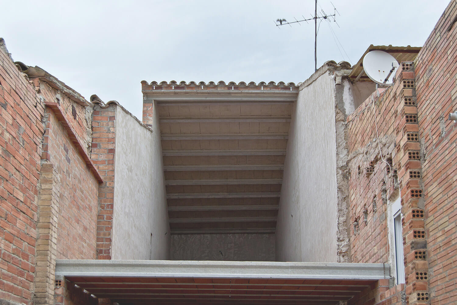 Housing restoration between dividing rammed earth wall - Fetdeterra